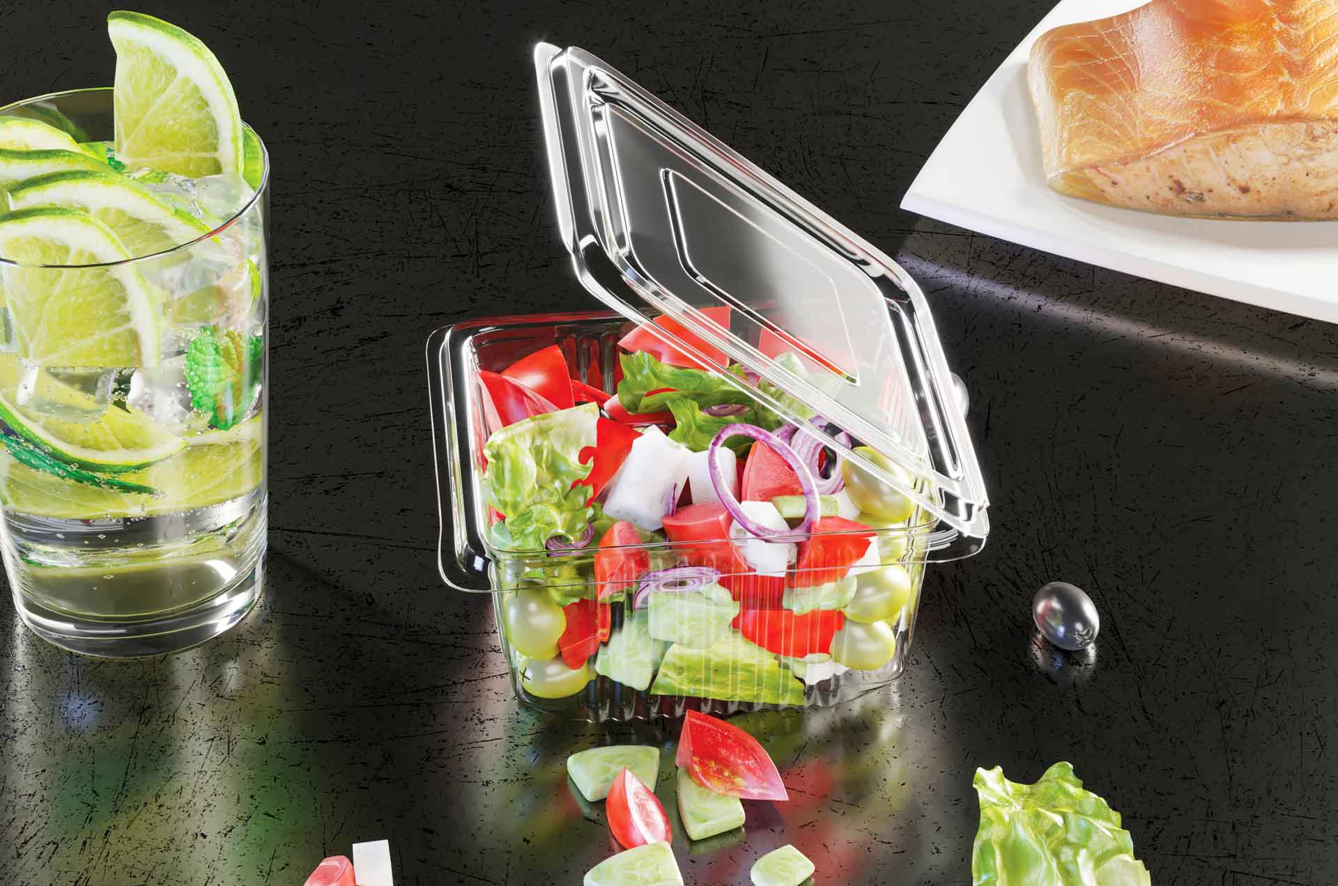 Şeffaf sızdırmaz kapta salata, yanında limonlu içecek